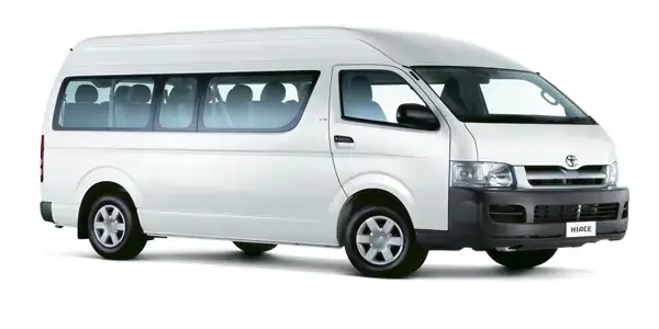 side image of a white 12 seater Toyota Hiace mini van